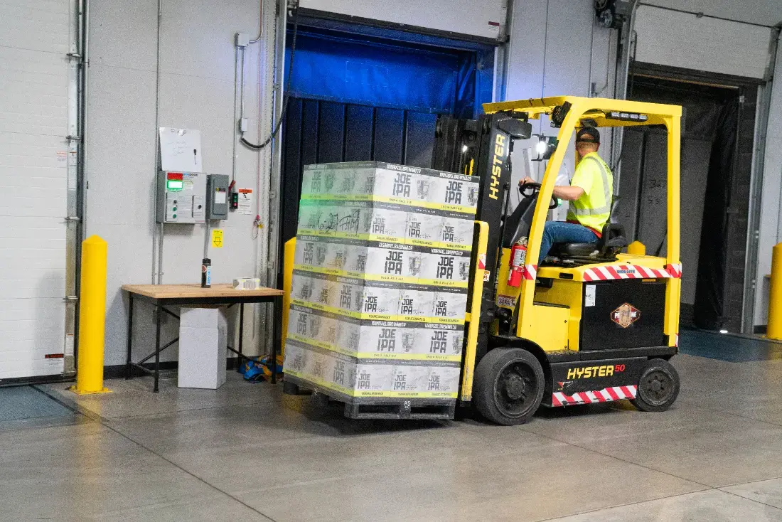Forklift moving a pallet in a warehouse